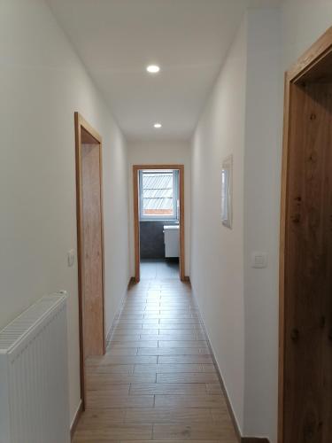 a hallway with white walls and a wooden door at Small wooden houses and Apartments Zgornja Dobrava in Radovljica