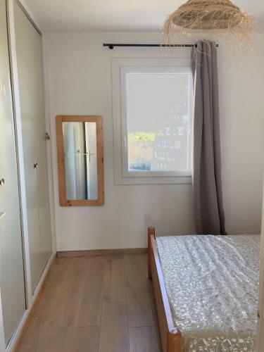 - une chambre avec une fenêtre, un lit et un miroir dans l'établissement Etoile dorée, vue mer, plage, clim, commerces, 3 étoiles, à La Grande Motte
