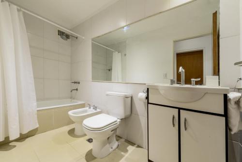 Baño blanco con aseo y lavamanos en Apartamento Amalfi en Belén de Escobar