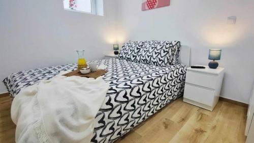 1 dormitorio con 1 cama con edredón blanco y negro en Casa de Praia Daniel en Lavra