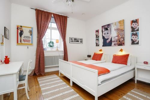a bedroom with a white bed and a desk at HagbackensGård Bed&Breakfast in Örebro