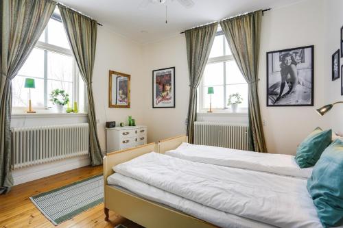 a bedroom with a bed and two windows at HagbackensGård Bed&Breakfast in Örebro
