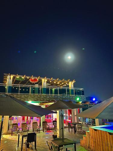 a deck of a cruise ship with tables and chairs at night at Hotel Dubaird in Santo Domingo
