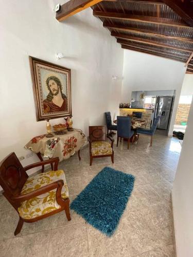 una sala de estar con sillas y una pintura en la pared en Apto. en zona céntrica con vista panorámica al pueblo en San Gil