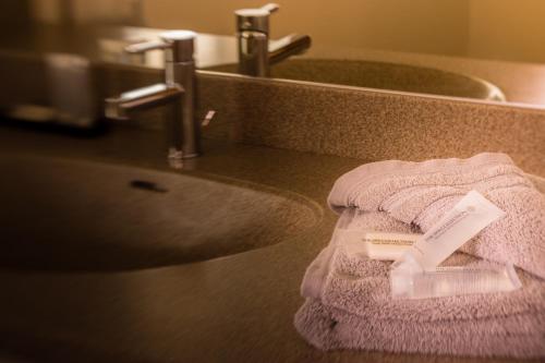Hotel Schwan في أوستريش-فينكل: بالوعة الحمام مع وجود منشفة على المنضدة