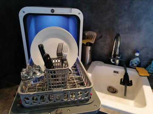 a dish drying rack sitting on top of a sink at L'île d'Olive, appartement entier 2 à 4 personnes terrasse 25 m2 Besançon, proche CV, Micropolis et CHU in Besançon