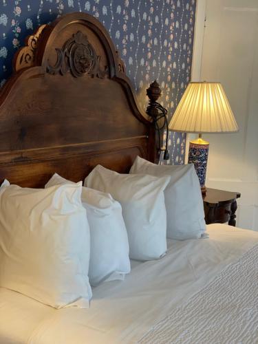 a bed with white pillows and a wooden head board at Central House Inn in Bar Harbor