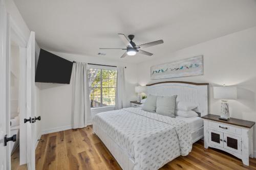 a white bedroom with a bed and a ceiling fan at SeabrookNook 3min2Beach Kemah Boardwalk NASA in Seabrook