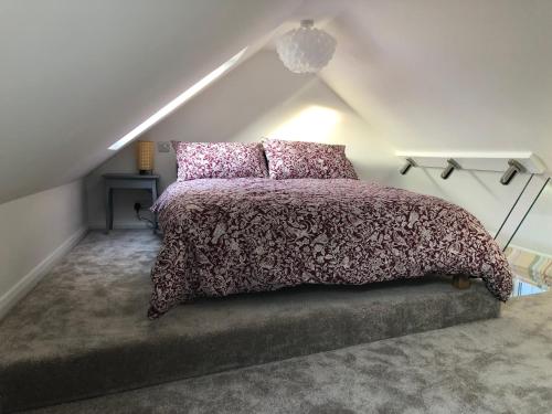 ein Schlafzimmer mit einem Bett im Dachgeschoss in der Unterkunft The Bolthole in South Hayling