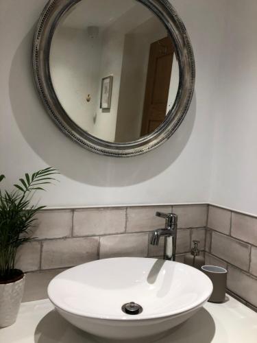 ein Badezimmer mit einem weißen Waschbecken und einem Spiegel in der Unterkunft The Bolthole in South Hayling