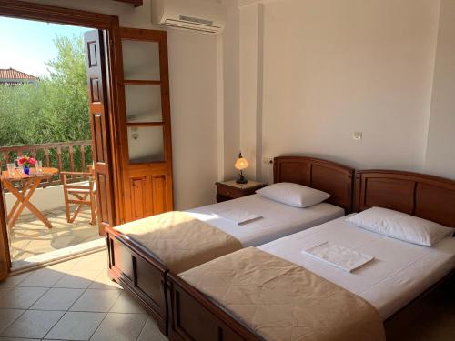 two beds in a bedroom with a balcony at Gaia Apartments By Villa Kokkoni in Marathokampos