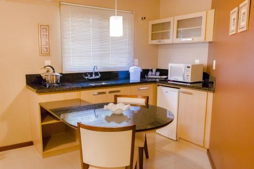 Una pequeña cocina con una mesa y un microondas. en Villa Flor Ecoresort, en Nova Petrópolis