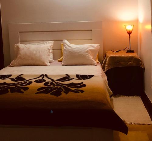 1 dormitorio con 1 cama grande y lámpara. en Mãe Home Foz, en Foz do Arelho
