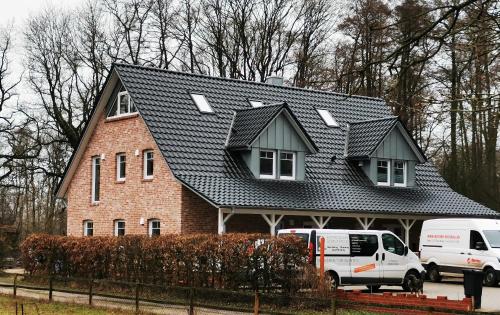 a house with a black roof on top of it at Ferienwohnung Meta Fischerhude in Ottersberg