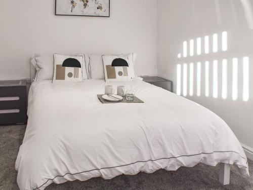 um quarto com uma grande cama branca e uma bandeja. em The Farmhouse - Uk42780 em Hemsby