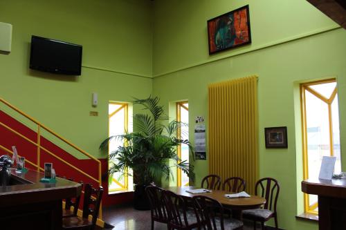 une salle à manger avec des murs verts, une table et des chaises dans l'établissement Hotel de Foetz, à Foetz