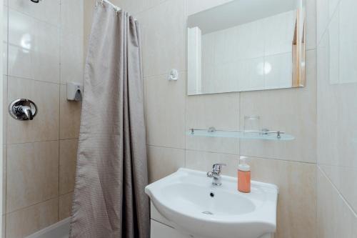 a white bathroom with a sink and a shower at Orava Hotel in Vitanová