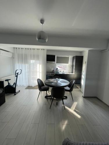 a living room with a table and chairs and a kitchen at Welcome to Bucharest Airport Residences & Therme-SELF CHECK-IN in Otopeni