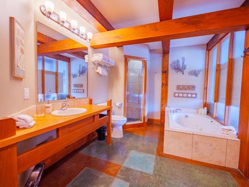 a bathroom with a tub and a toilet and a sink at Whisky Harbour, Downtown King Bed and Inlet View in Ucluelet