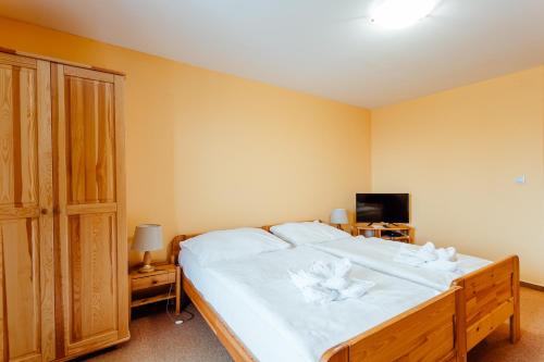 a bedroom with a large bed with white sheets at Orava Hotel in Vitanová