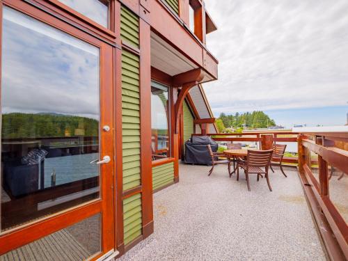 a patio with a table and chairs on a balcony at Whisky Harbour, Downtown King Bed and Inlet View in Ucluelet