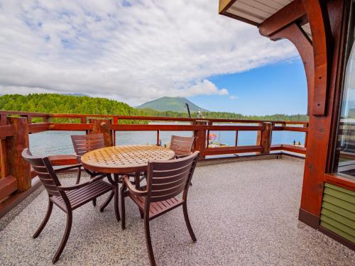 a table and chairs on a balcony with a view of the water at Whisky Harbour, Downtown King Bed and Inlet View in Ucluelet