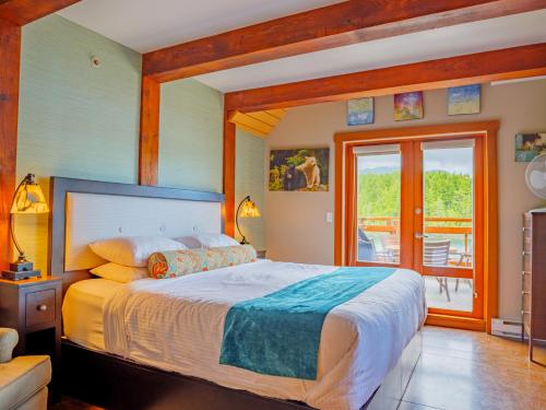 a bedroom with a large bed and a balcony at Whisky Harbour, Downtown King Bed and Inlet View in Ucluelet