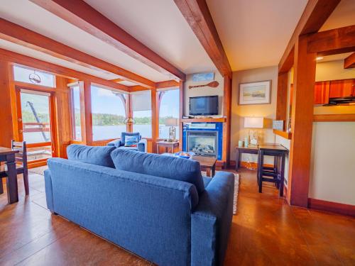 a living room with blue couches and a fireplace at Whisky Harbour, Downtown King Bed and Inlet View in Ucluelet
