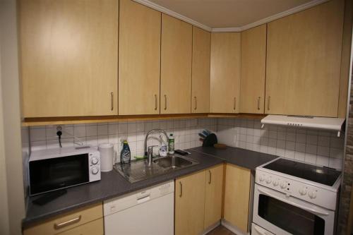 a kitchen with a sink and a microwave at Sentral leilighet med 3 soverom 2etg in Harstad