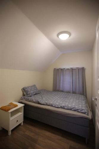 a small bedroom with a bed with a curtain at Sentral leilighet med 3 soverom 2etg in Harstad