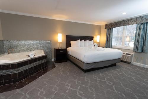 Habitación de hotel con cama y bañera en Golden Apple Inn, en Glen