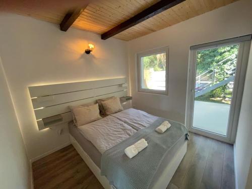 een slaapkamer met een bed met twee handdoeken erop bij Felix House Siófok in Siófok