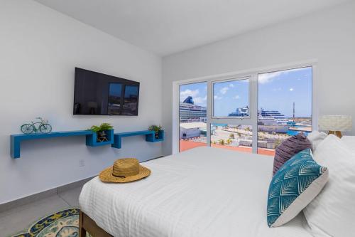 a bedroom with a large bed and a flat screen tv at Aruba Dreams Take Me Away Studio in Oranjestad