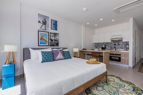a bedroom with a large bed and a kitchen at Aruba Dreams Take Me Away Studio in Oranjestad