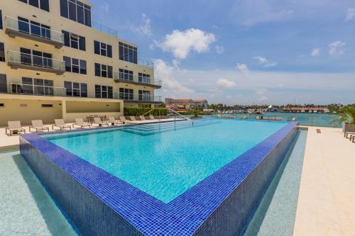 a large swimming pool with blue tiles on the side of a building at Aruba Dreams Take Me Away Studio in Oranjestad