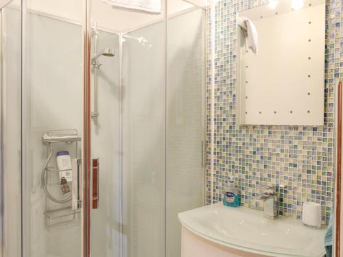 baño blanco con ducha y lavamanos en Dee Valley View en Aboyne