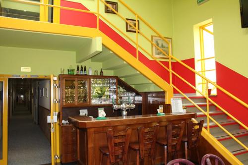 a bar with a yellow and red stairway at Hotel de Foetz in Foetz