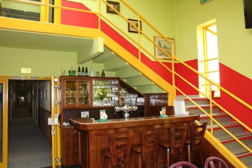 un bar avec un escalier jaune et rouge dans l'établissement Hotel de Foetz, à Foetz