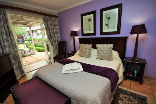 a bedroom with a large bed with purple walls at Avalon Guest Manor in Newcastle