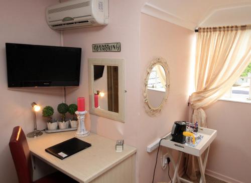 a room with a desk with a tv on the wall at Avalon Guest Manor in Newcastle