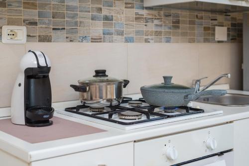 a tea kettle and a pot on a stove in a kitchen at Good Time Apartment in Ciampino