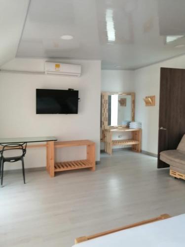 a living room with a table and a tv on a wall at Hotel 42 Avenida in Palmira