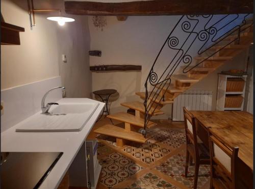 una cocina con fregadero y una escalera en una habitación en Casa Chidro, en Buesa