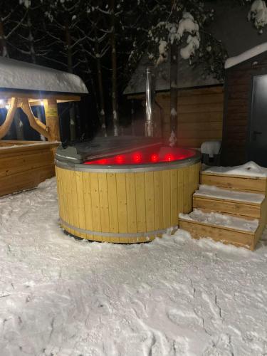 a hot tub with red lights in the snow at Ośrodek u Polaka-domek góralski in Radkowice
