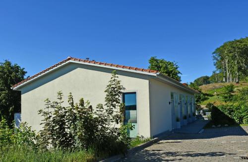 un pequeño edificio blanco con muchas ventanas en schöne Ferienwohnungen mit Kamin im Ostseebad Sellin Kopie en Ostseebad Sellin