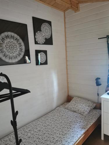a bed in a room with pictures on the wall at CICHOsza in Lubkowo