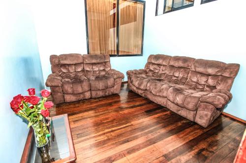 a living room with two couches and a table at Hotel Colonial in Puyo