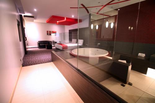 a bathroom with a glass counter with a tub in it at Motel Via in Tijuana