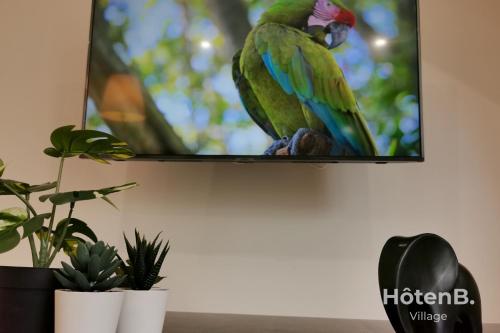 a parrot is sitting on a tv screen at "La Boétie" - 50 m2 de charme Limoges Centre in Limoges