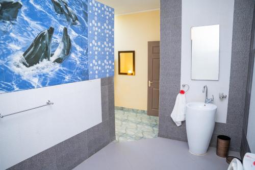 ein Bad mit einem WC und einem Wandgemälde in der Unterkunft Green Park in Beau Vallon